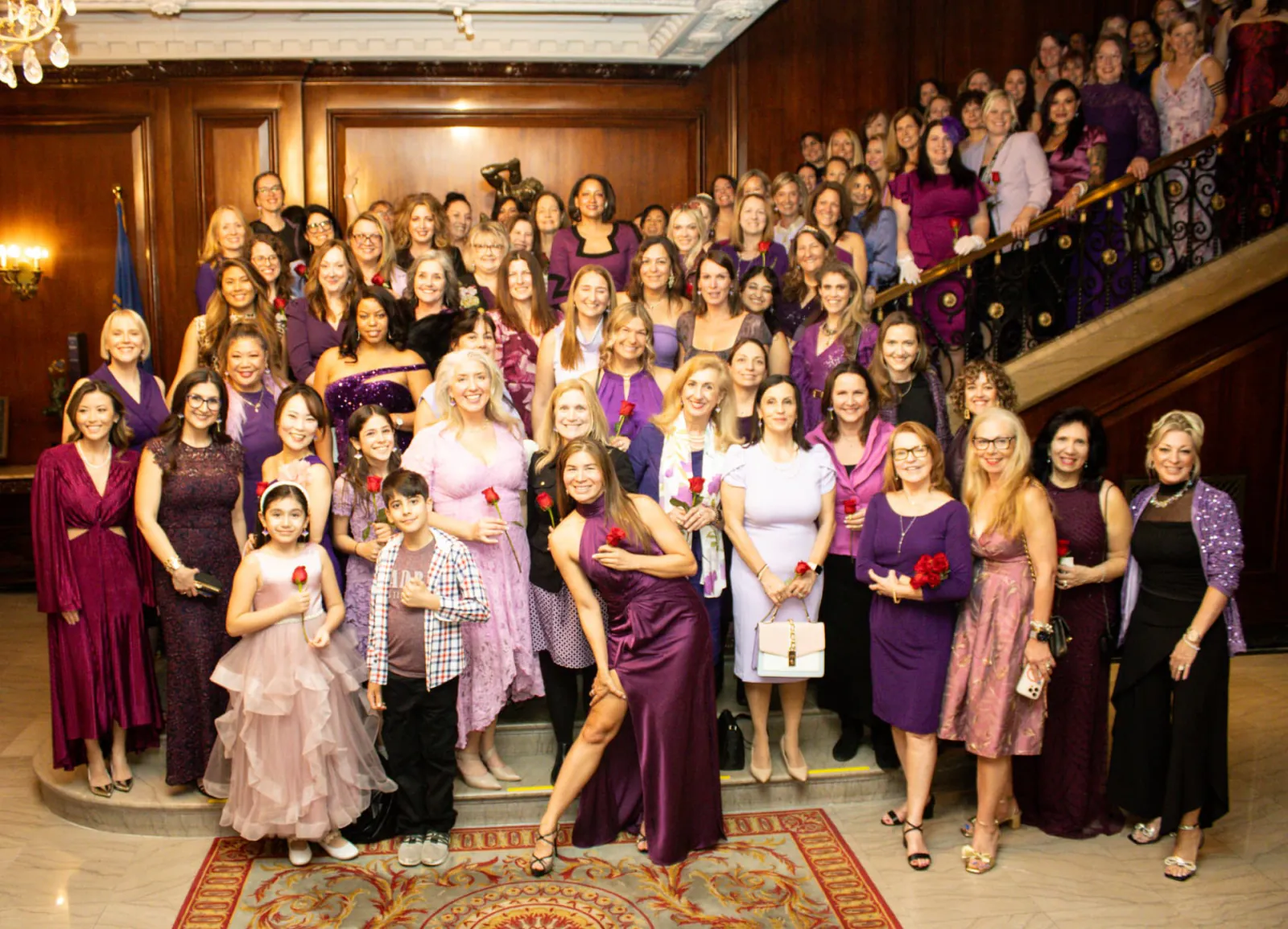 Guests in evening attire gathered on the steps of a grand staircase